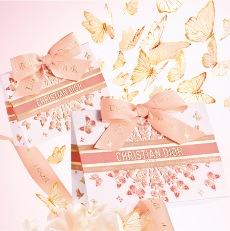 Twee Art of Gifting Dior-cadeauzakjes versierd met gouden vlinders en een roze Dior-lint.