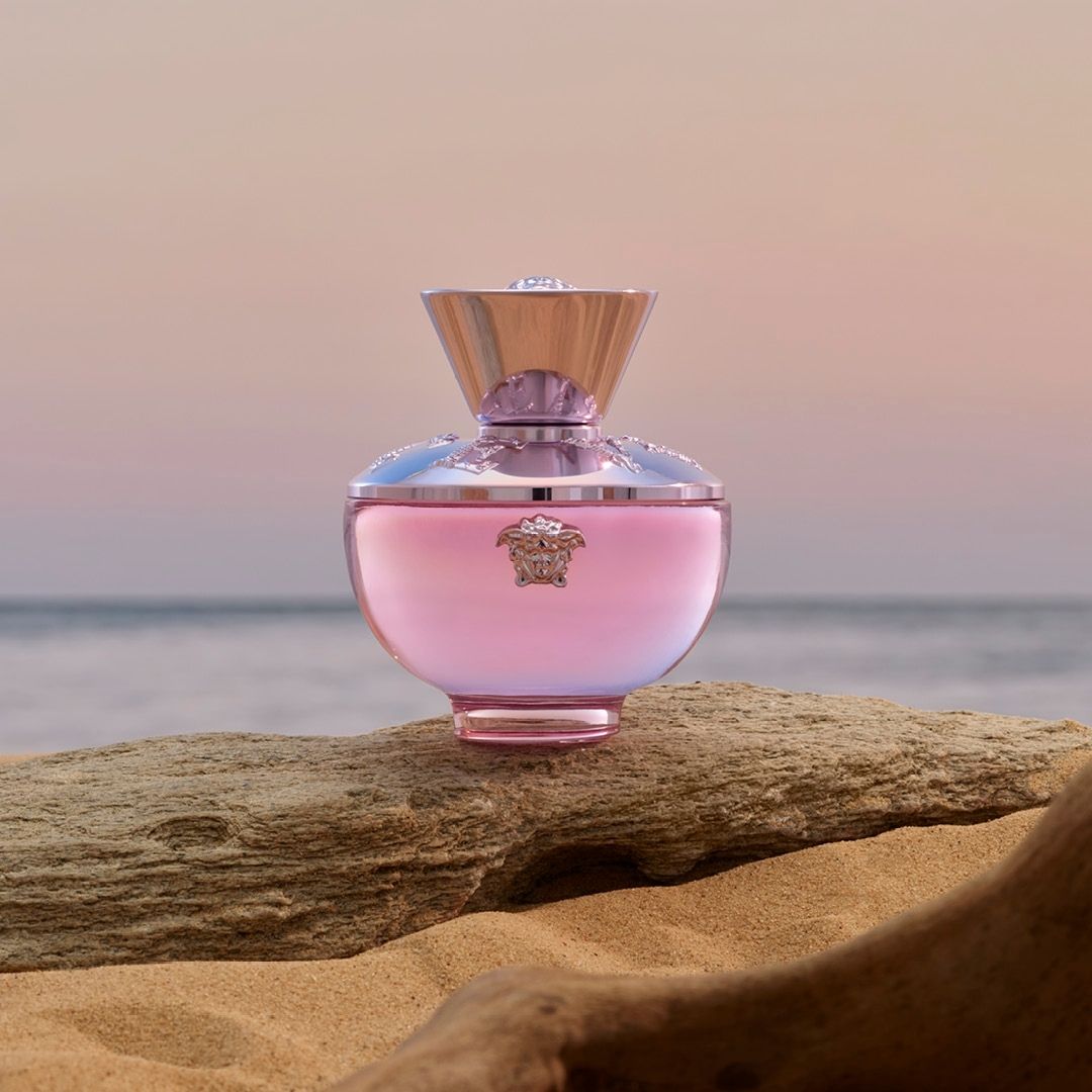 Versace Dylan Blush Pink Perfume displayed on a stone with  the sea in the background.