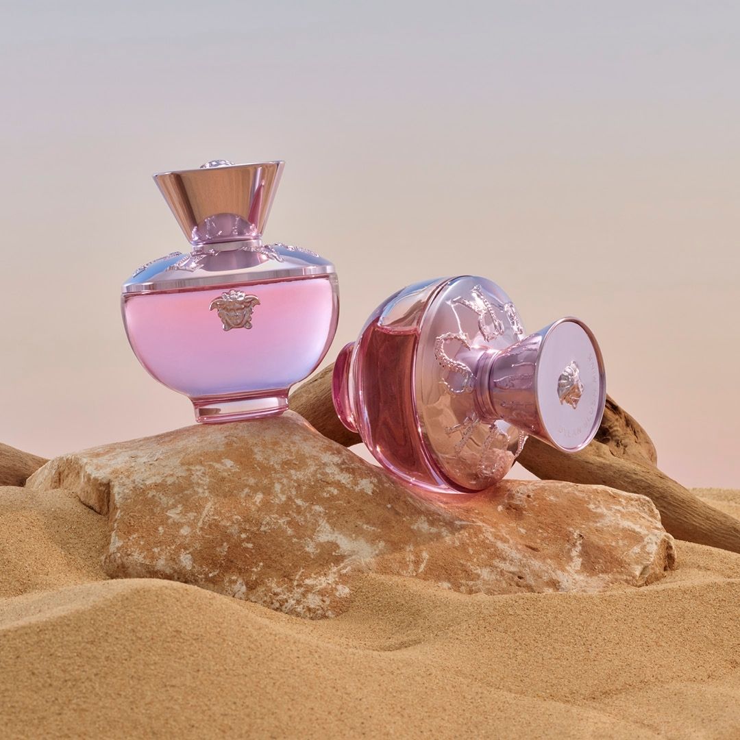 Two Versace Dylan Blush pink perfume bottles displayed on a stone,