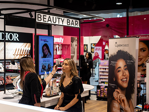 Conseiller d'ICI PARIS XL appliquant du maquillage à un client au Beauty Bar du magasin.