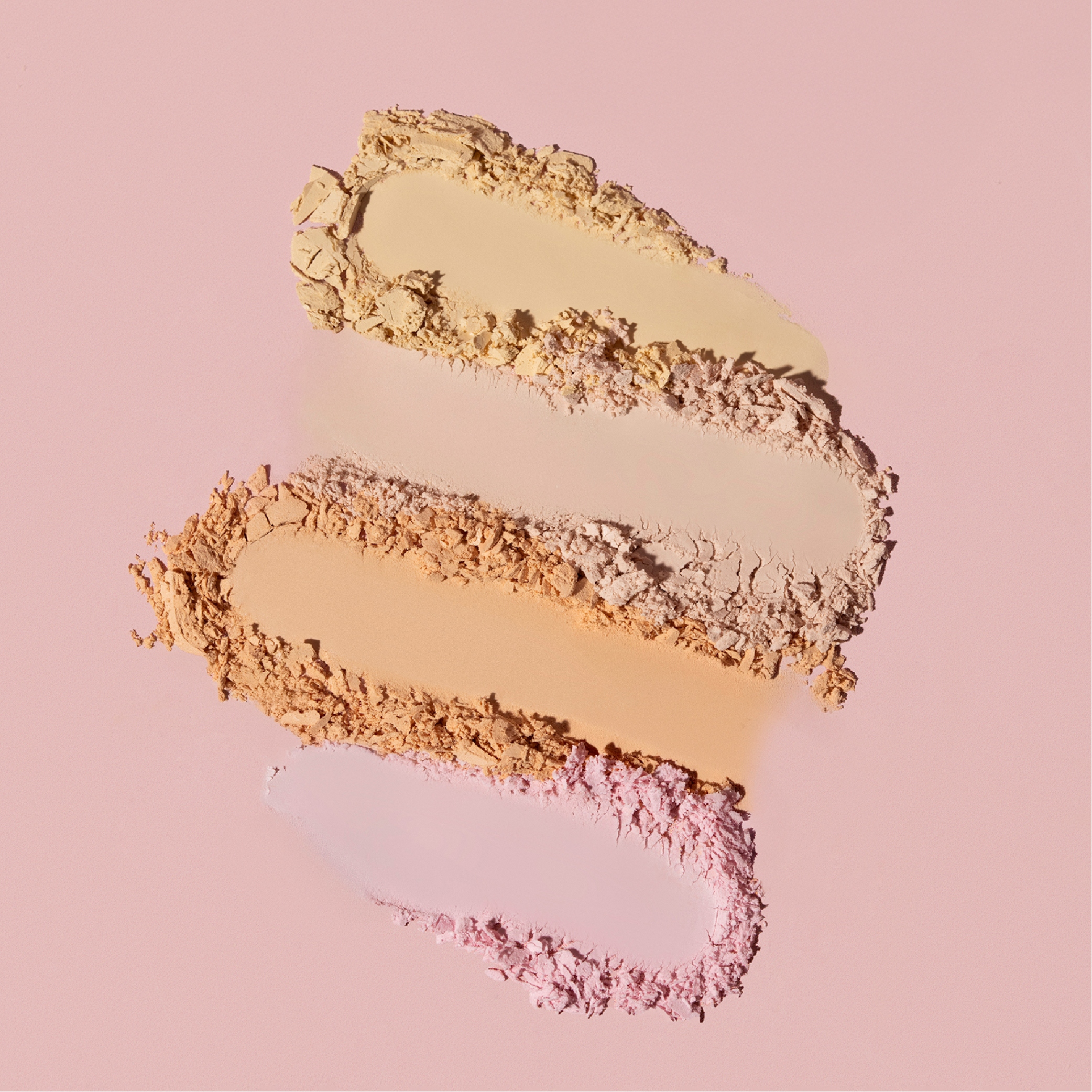 Close-up van gemalen poeder in beige en roze tinten op een roze achtergrond