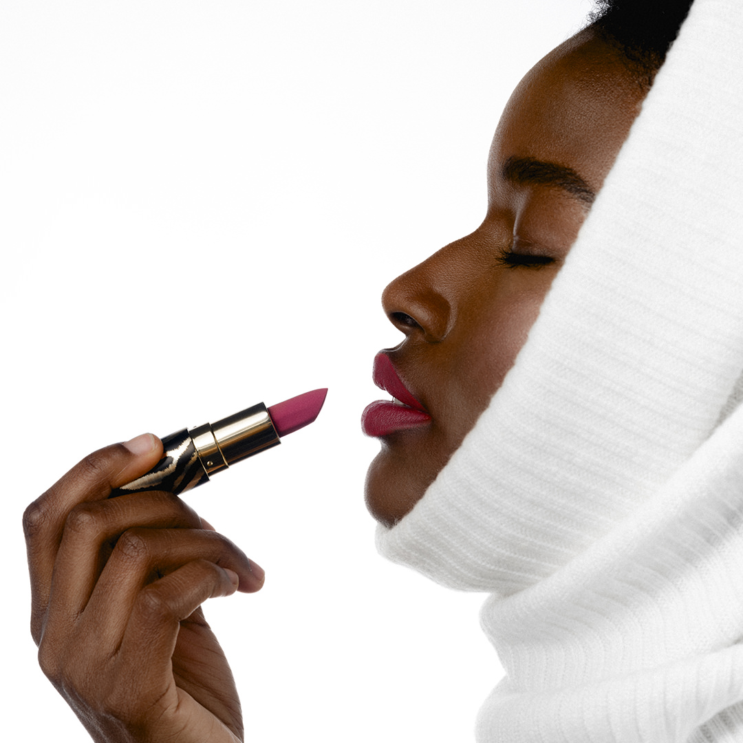 Side profile of black model applying Sisley Phyto-Rouge Velvet Lipstick