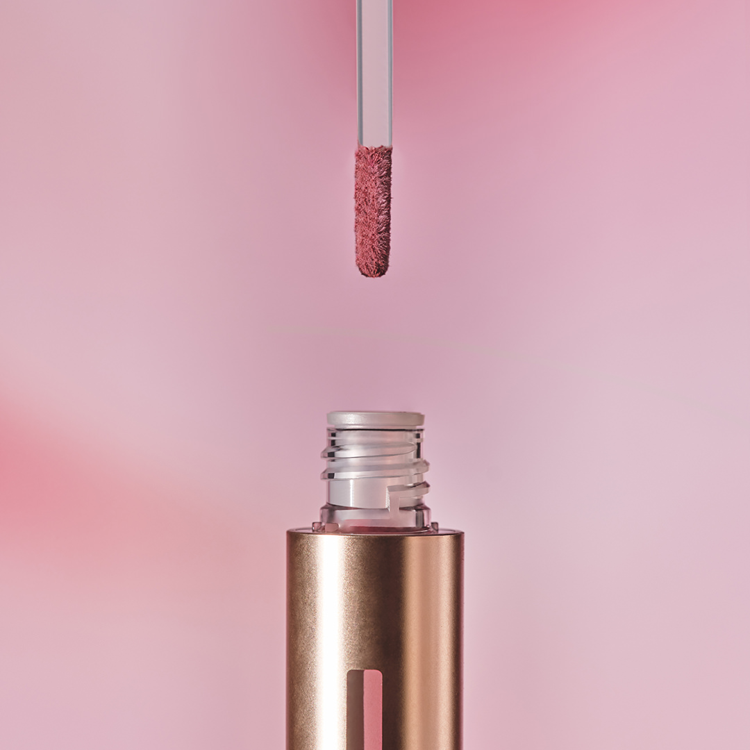 Sisley Color Cloud applicator above a gold tube with pink background
