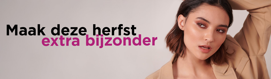 Een mooi opgemaakte vrouw met een stralende lach, in een beige pak
