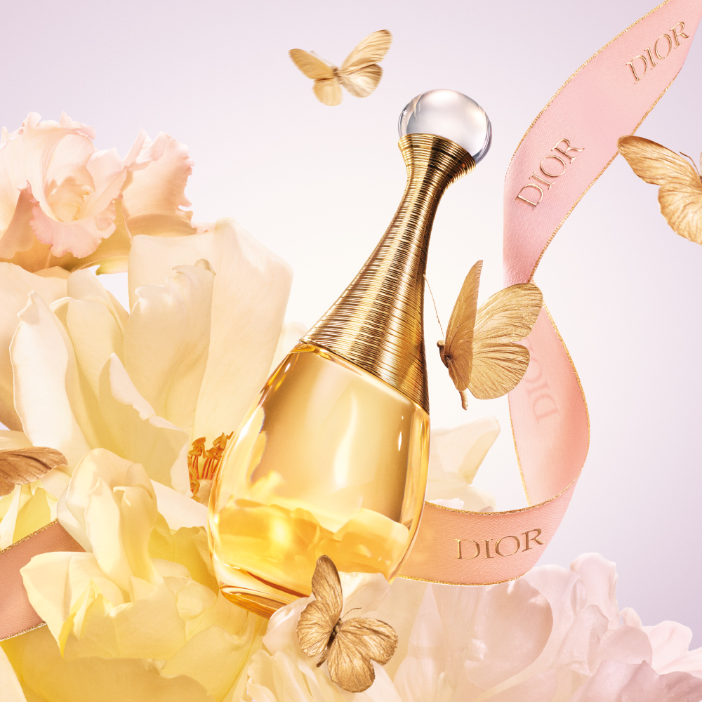 J’adore Eau de Parfum flacon op een achtergrond met bloemen en vlinders