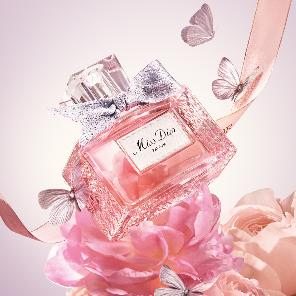 Miss Dior Parfum flacon op een achtergrond van bloemen en vlinders