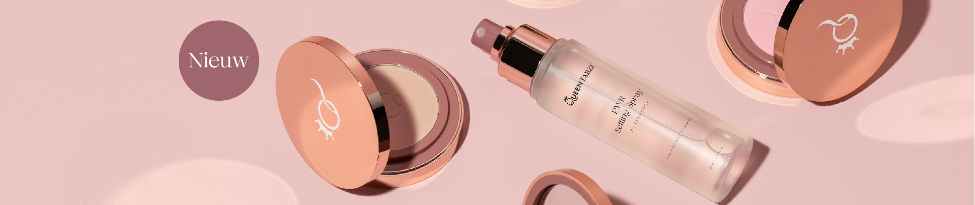 Afbeelding met roze achtergrond, luxe make-up producten van Queen Tarzi (dream pressed powder en PWR setting spray) elegant neergelegd.