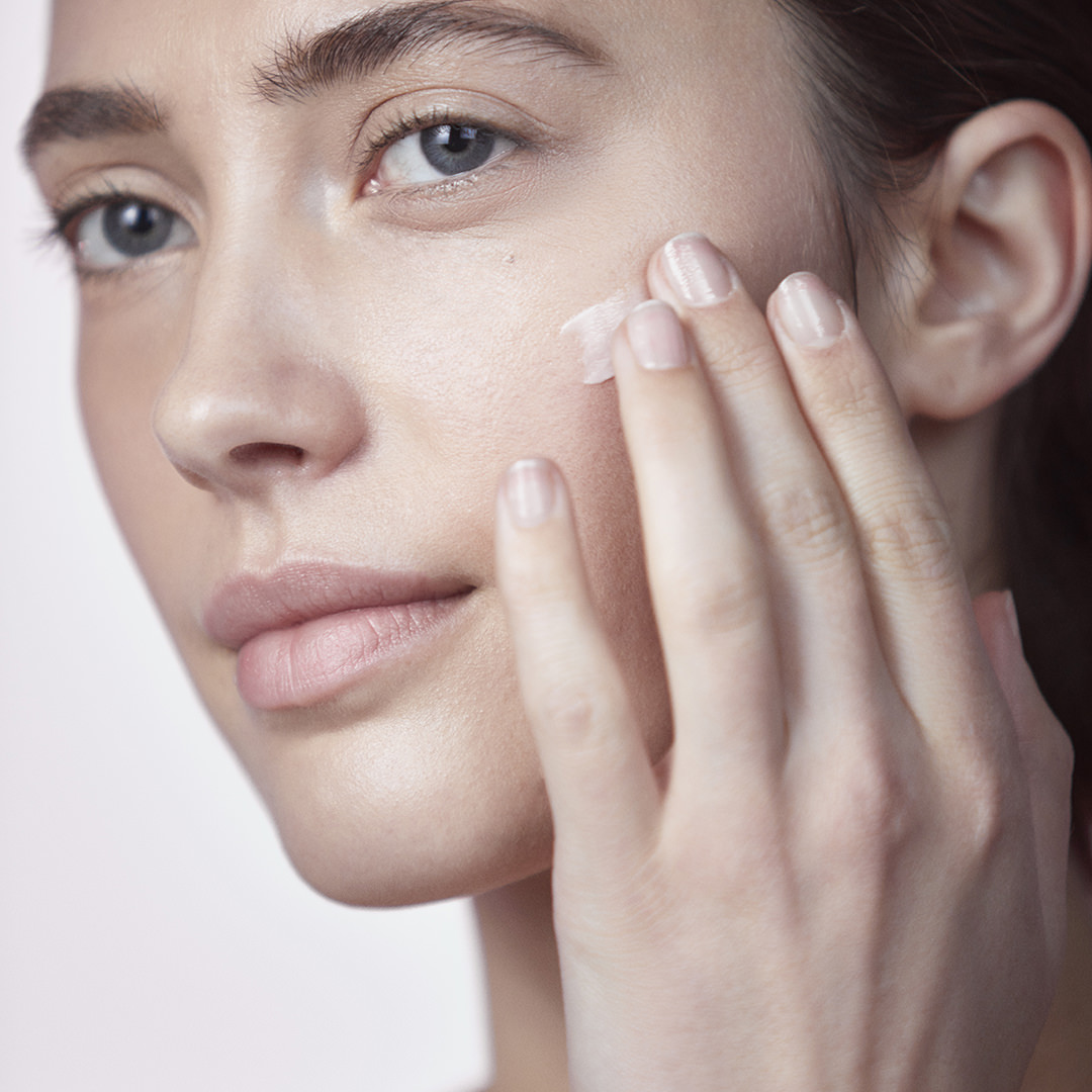 Woman touching face with gentle expression